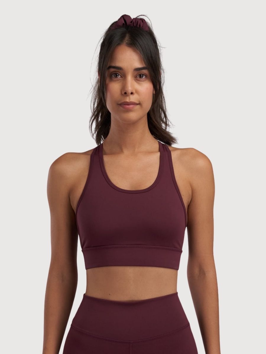 A-DAM Sport Bra in Clementine recycled polyester, showing a fitted athletic bra with adjustable straps and a supportive design.